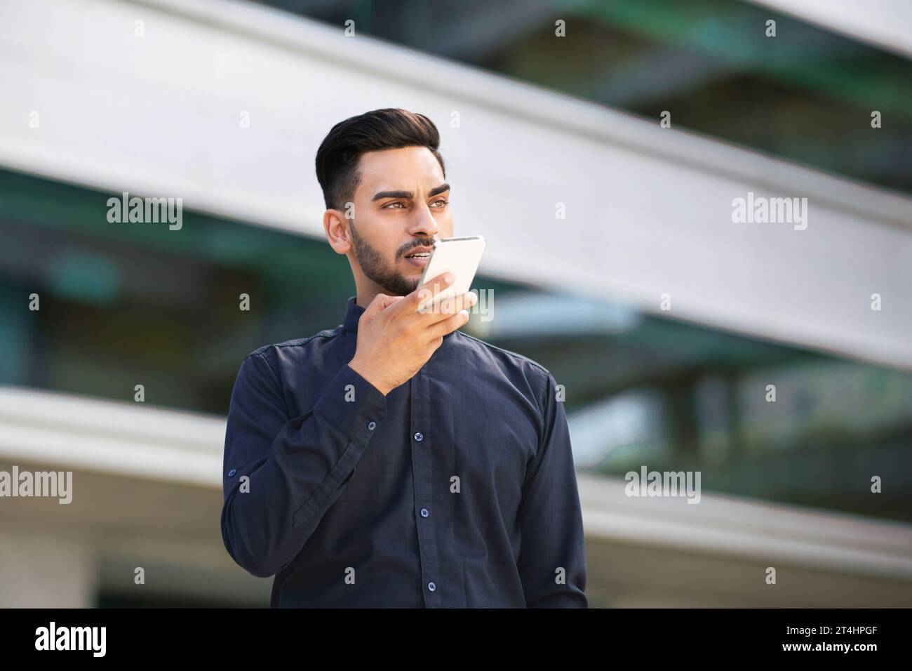Arabic Business Man Using Voice Search Application On Smartphone Outdoors Stock Photo