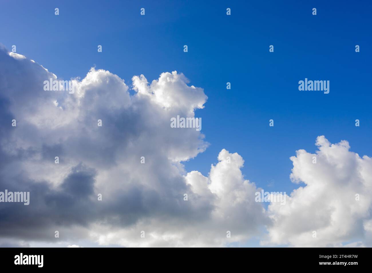 Blue sky background with fluffy grey and white clouds Stock Photo