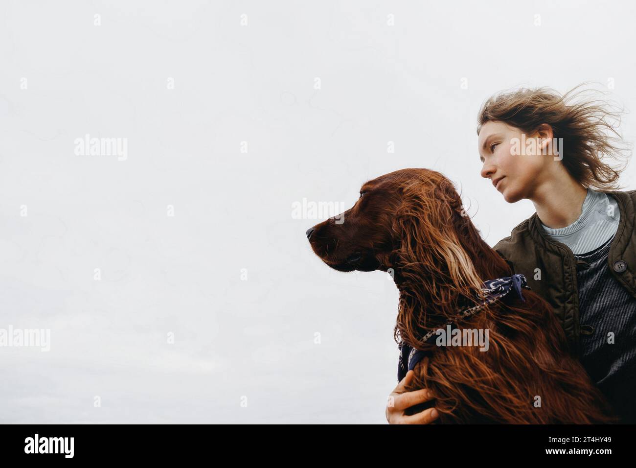 Portrait of a young woman with her dog. Irish setter dog and mistress looking side at place for your advertise. Copy space Stock Photo