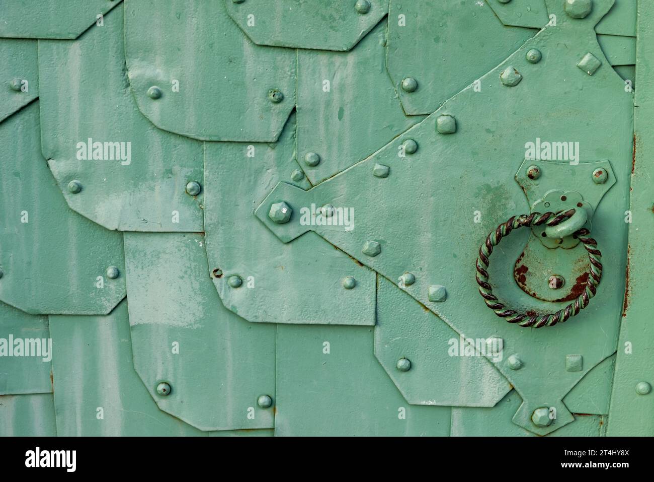 Old green metal door with a ring handle, close up texture Stock Photo