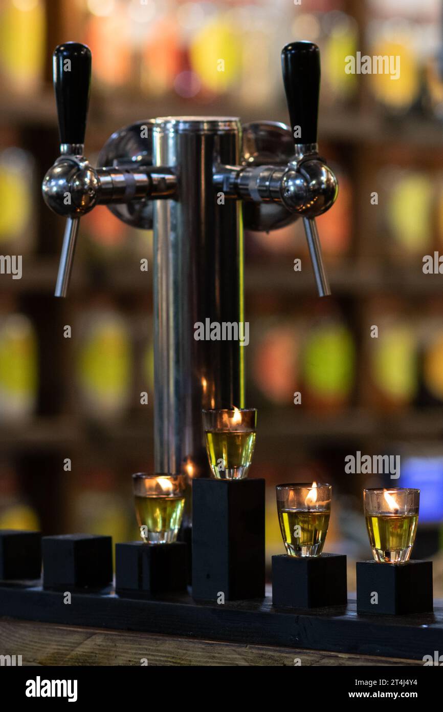Hanukkah oil candles burn brightly beside beer taps in a bar in the Machane Yehuda market in Jerusalem during the celebration of the Festival of Light Stock Photo