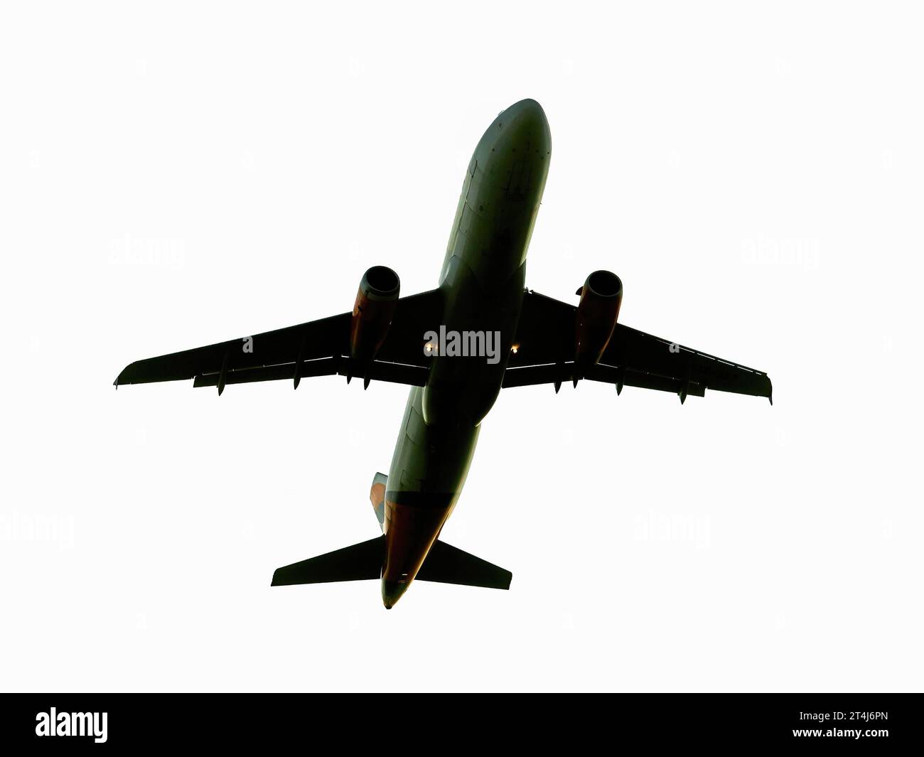 Flying airplane on white background. Real plane in the sky view from down up. Real jet aircraft isolated on white. Stock Photo