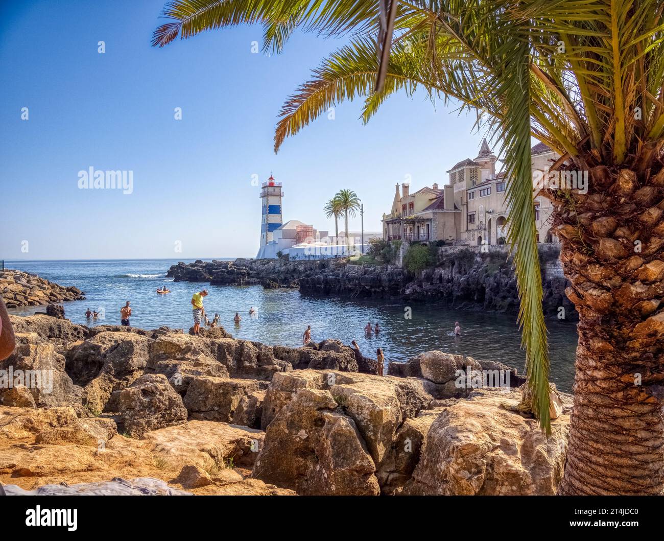 The Santa Marta Lighthouse on a small cove swimming area off the Atlantic Ocean in Cascais Portugal Stock Photo