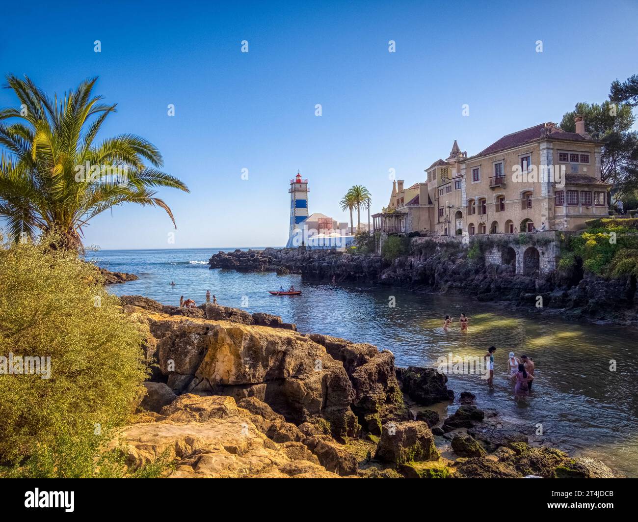 The Santa Marta Lighthouse on a small cove swimming area off the Atlantic Ocean in Cascais Portugal Stock Photo