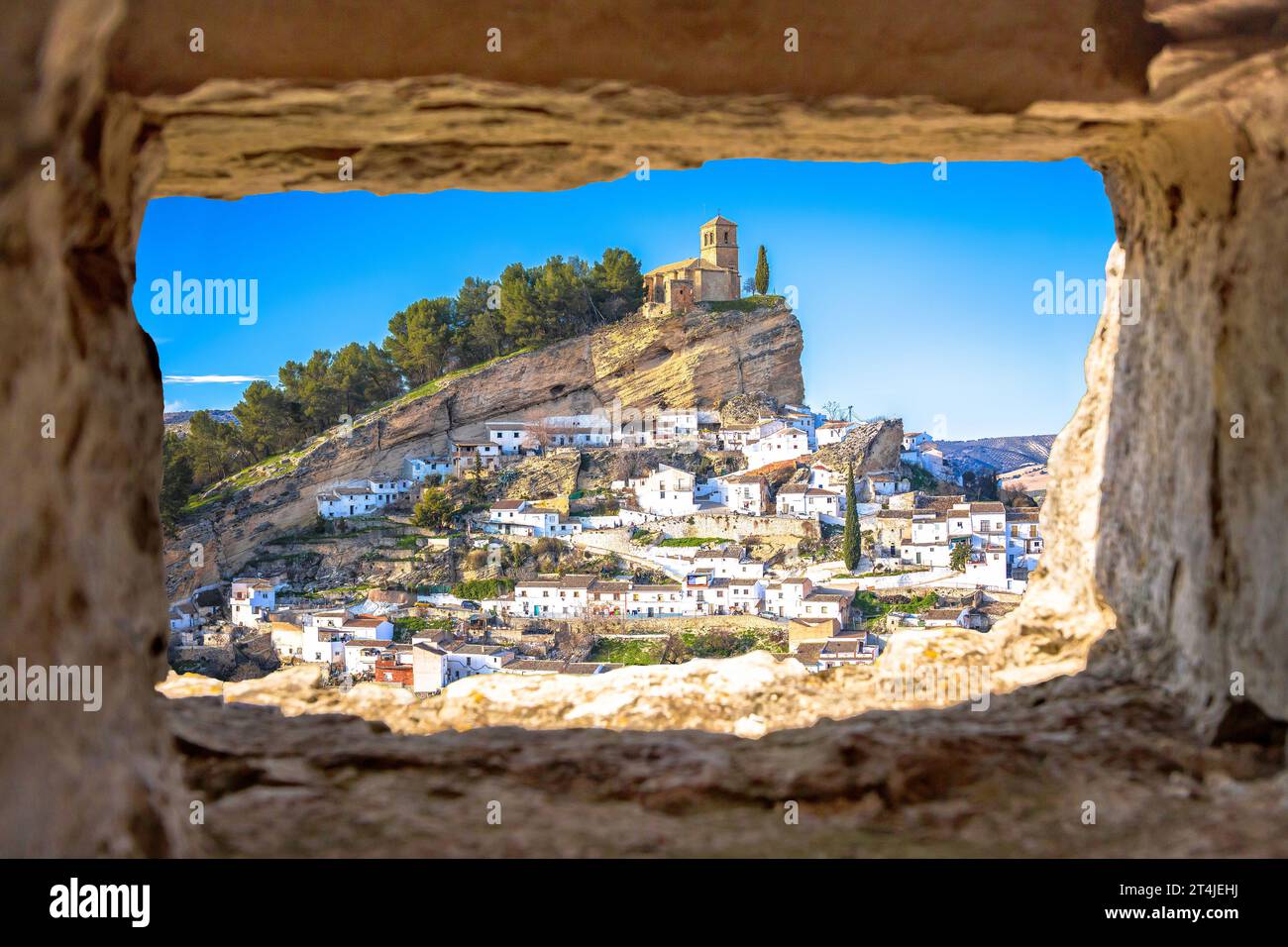 Scenic white village of Montefrio near Granada view through stone window, Andalusia region of Spain Stock Photo