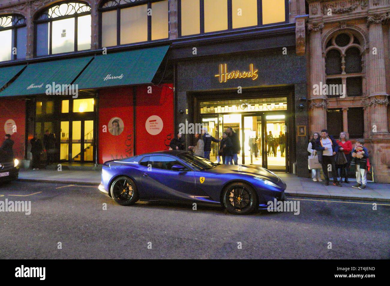 Knightsbridge, London, UK  30th October, 2023  Rich folks park their Ferrari ÒshoppingÓ car outside the Hans Road entrance to the famous Harrods department store Stock Photo