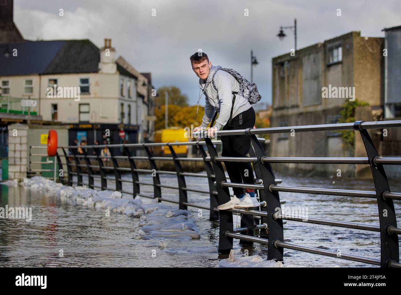 A man walks along a fence to avoid flood water in Newry Town, Co Down