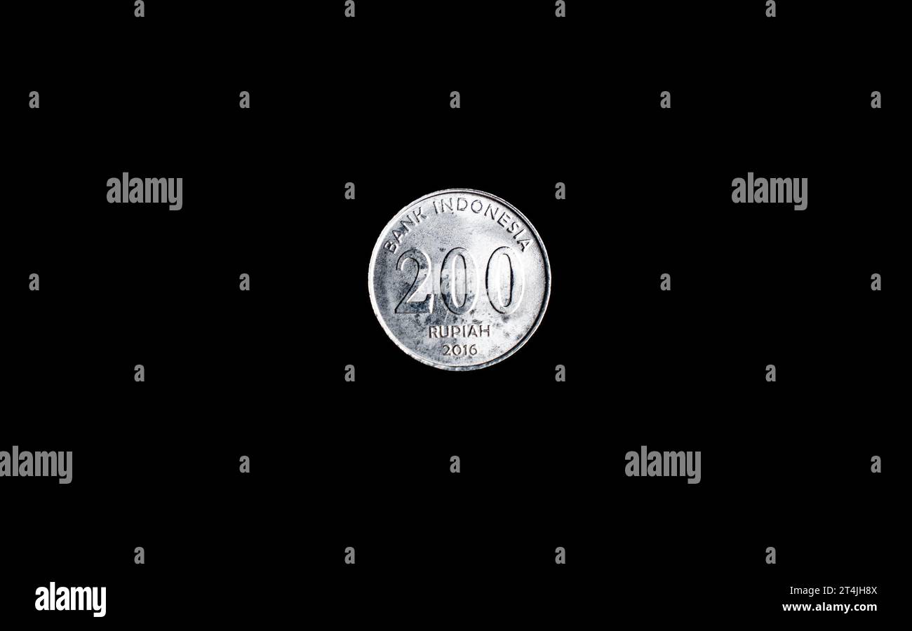 Uang koin Indonesia dua ratus 200 rupiah, Indonesian two hundred rupiah coin with black background, top view, isolated. Stock Photo
