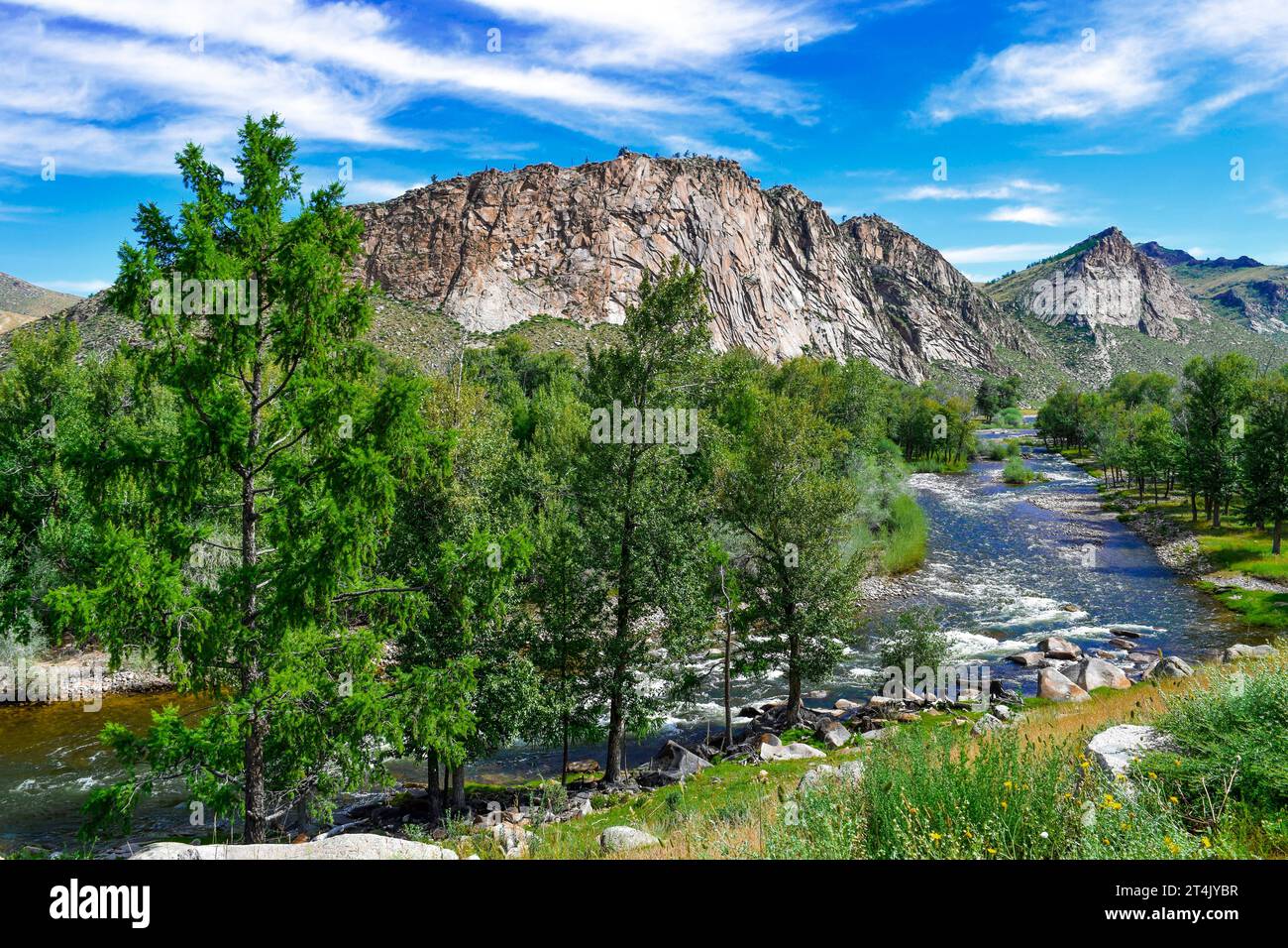 A tranquil river winding its way through lush green hills and trees ...