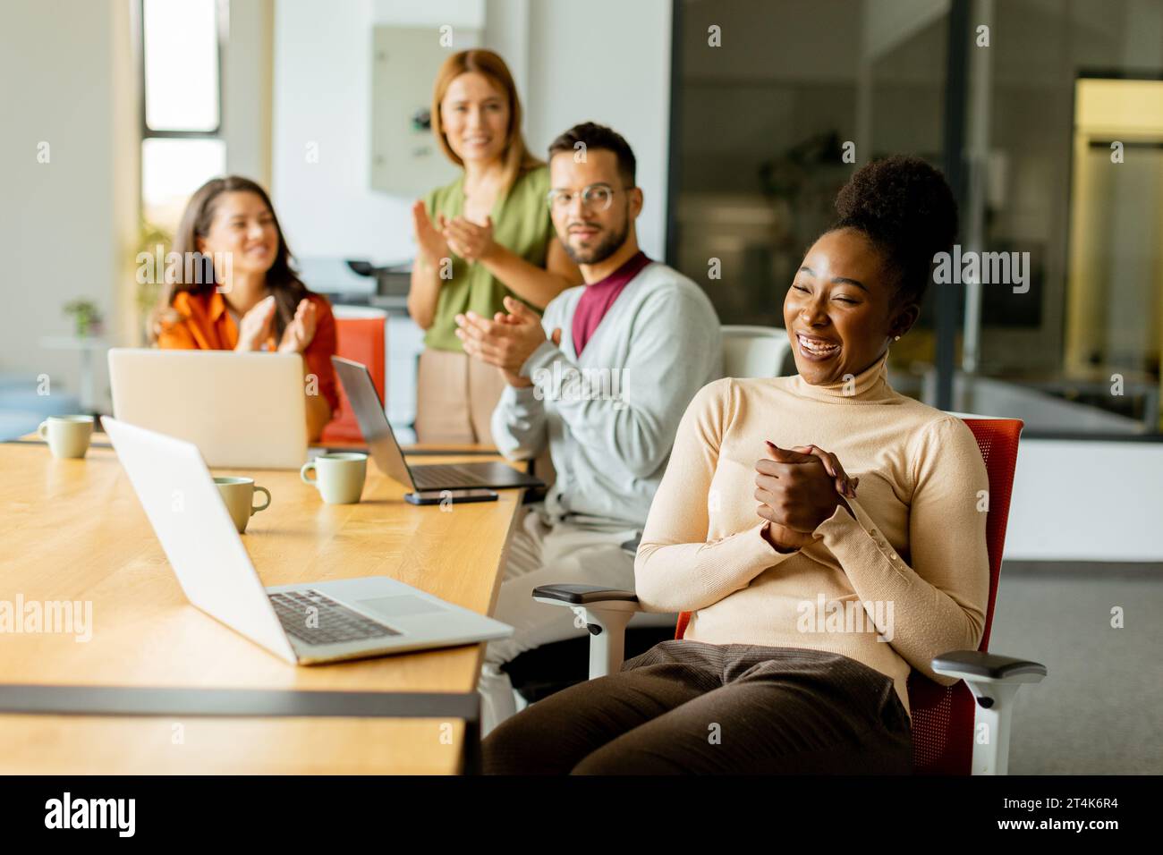 Cute Africam American woman with her young multiethnic startup team working at the modern office Stock Photo