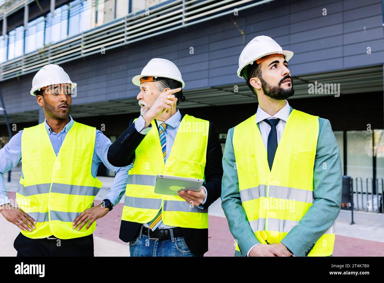 Three construction engineers having a discussion on building site. Stock Photo