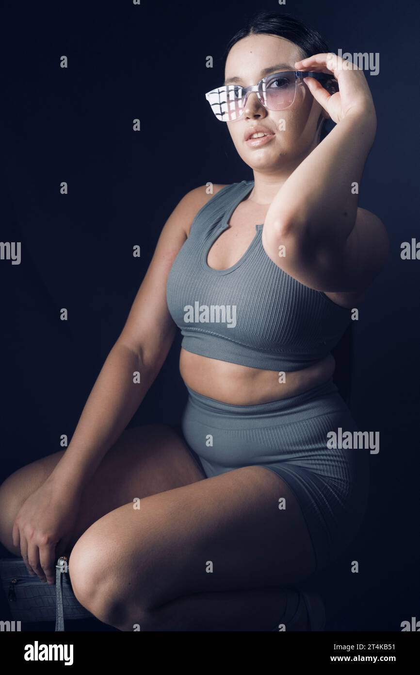 Curvy influencer fitness gym girl posing studio shot. Stock Photo