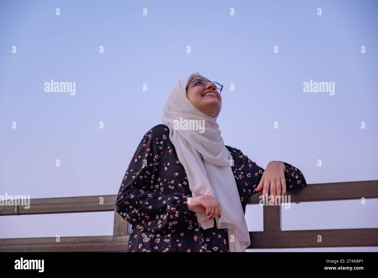 female wearing hijab and islamic wears having vacation in resort with smile on their face and beautiful blurred lights in the background Stock Photo