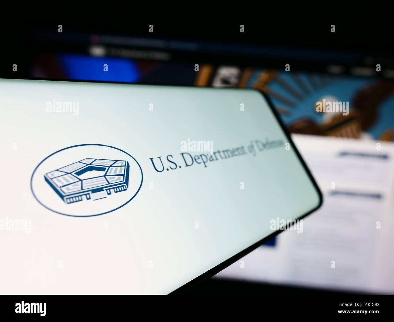Cellphone with logo of United States Department of Defense (DoD) in front of website. Focus on center-left of phone display. Stock Photo