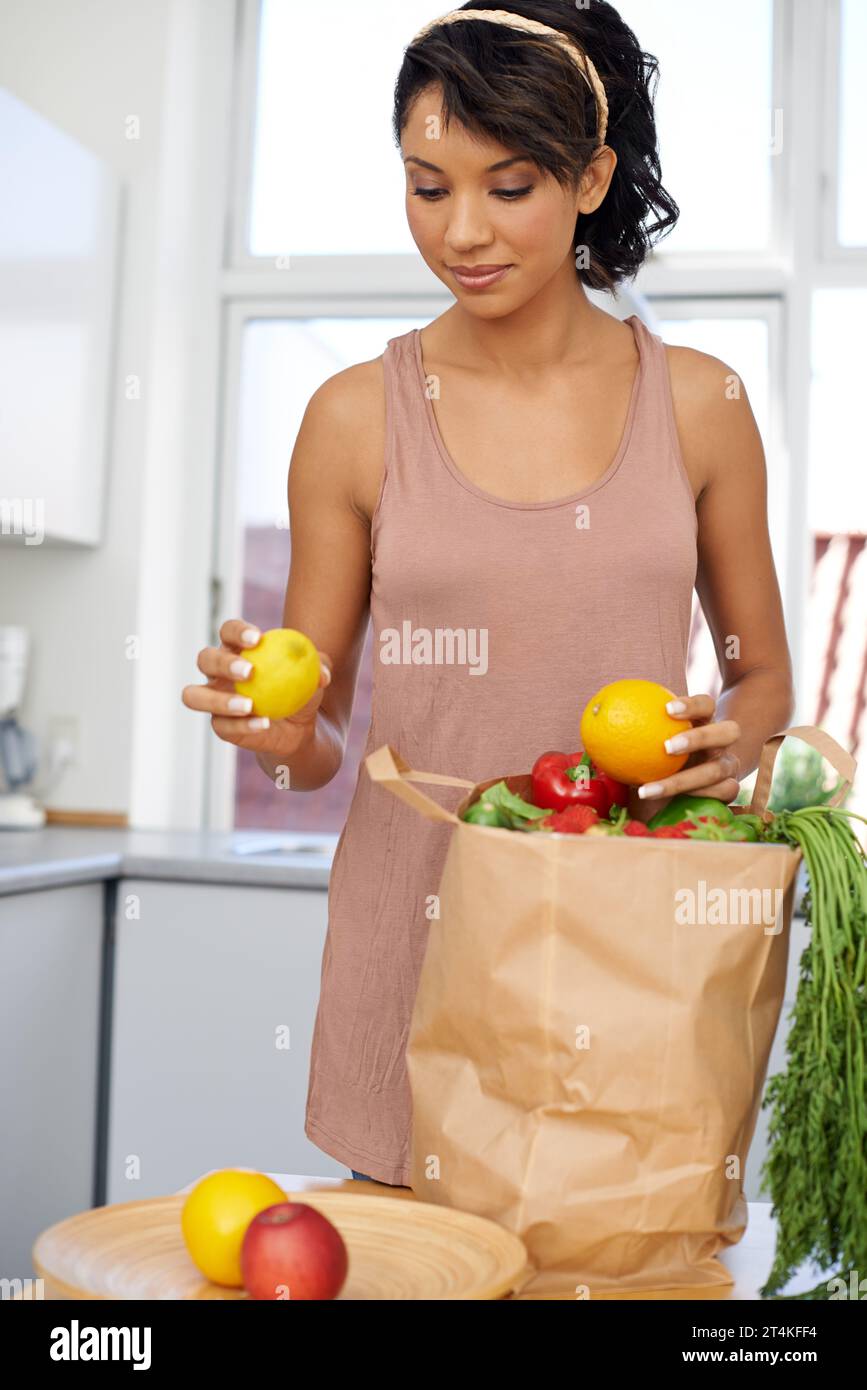 Kitchen, vegetables and woman with groceries, consumer and wellness with retail, package and customer. Person, client and girl with nutrition, home Stock Photo