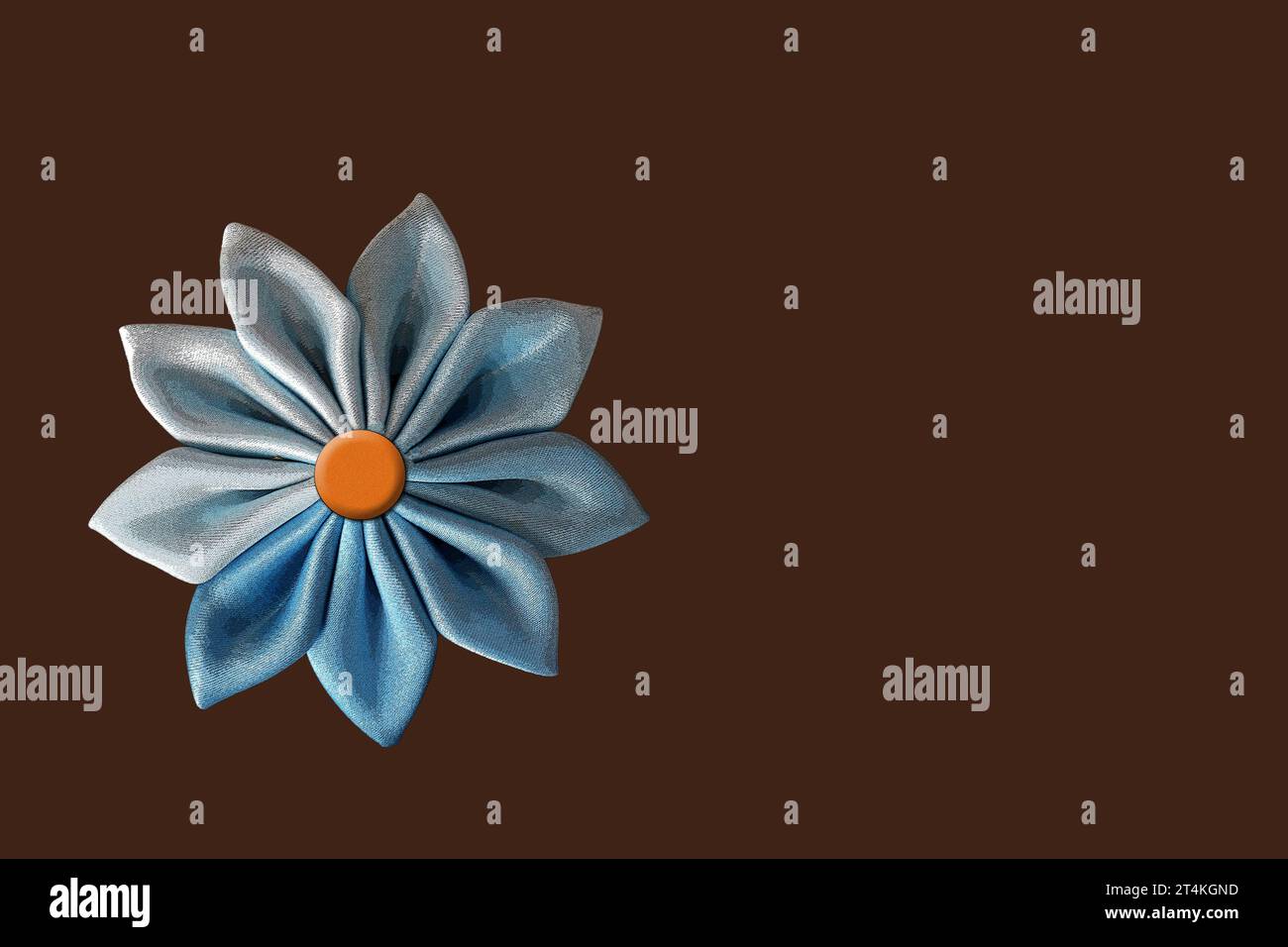 Blue fabric flower illustration isolated on brown background with copy space Stock Photo