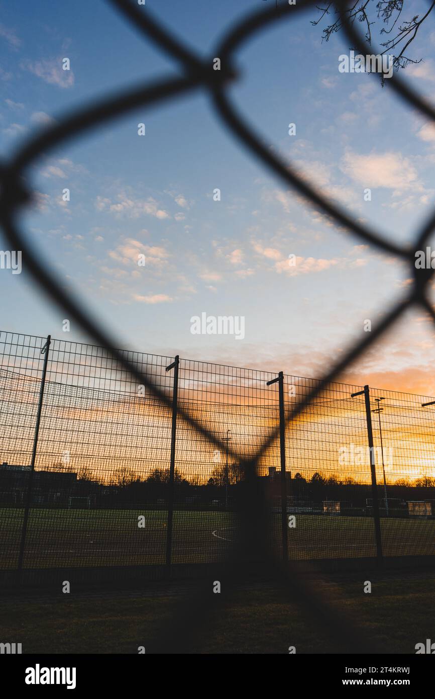 wire mesh fence in front of sunset sky Stock Photo