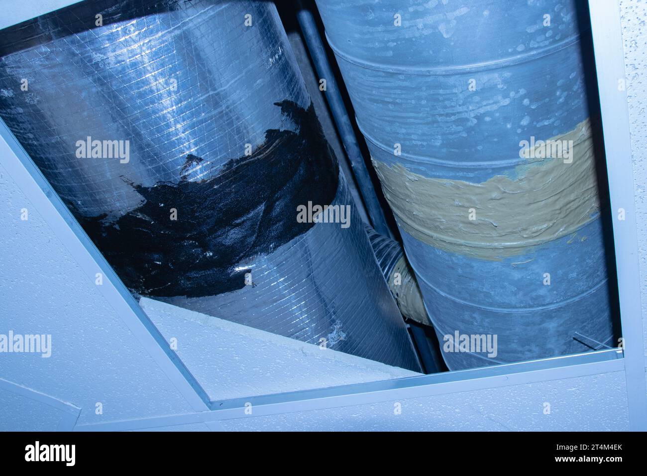 Black and gold asbestos mastic on AC duct work Stock Photo Alamy