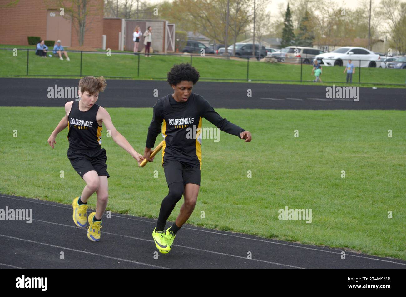 Two young men in a relay race passing the baton Stock Photo