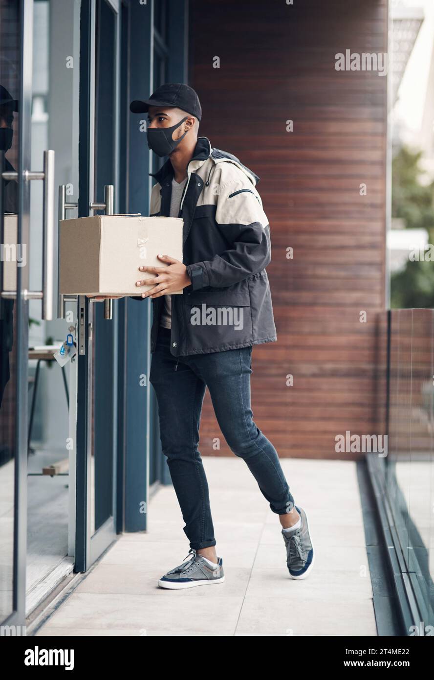 Hello, your delivery is here. a masked young man delivering a package ...