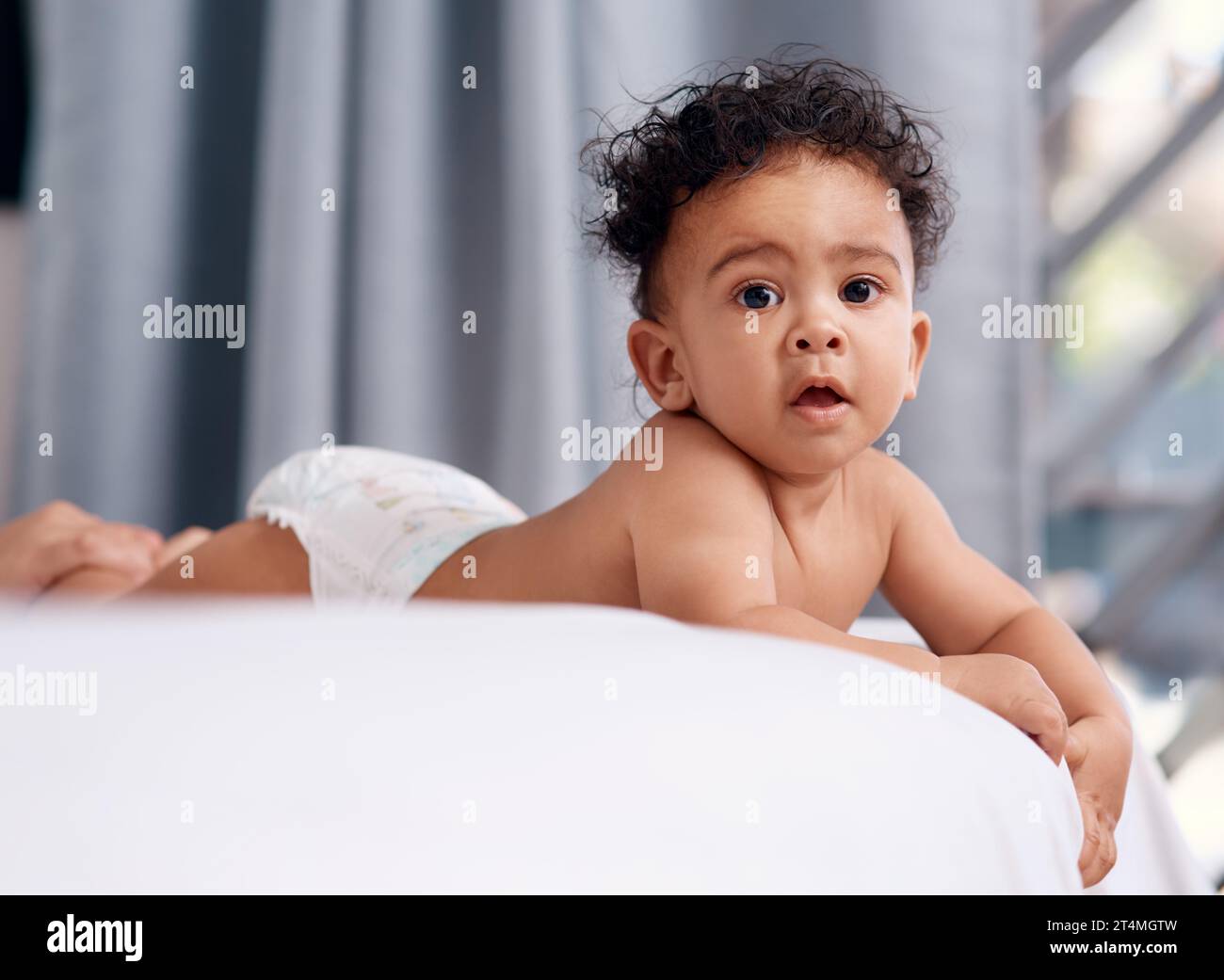 Life got a lot cuter when I came along. an adorable baby boy on the bed at home. Stock Photo