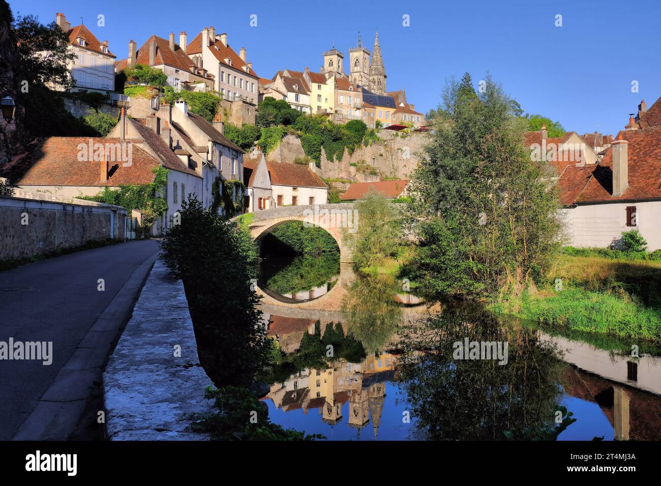 Semur-en-Auxois: Pont Pinard bridge and church soon before sunset with mirror reflections in River Armançon, Burgundy, France Stock Photo
