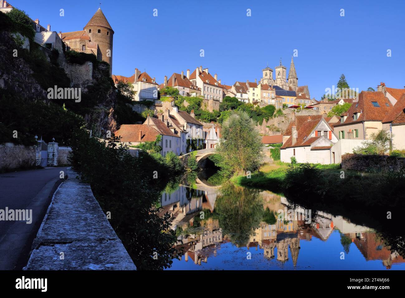 Semur-en-Auxois: Pont Pinard bridge, church and tower soon before sunset with mirror reflections in River Armançon, Burgundy, France Stock Photo