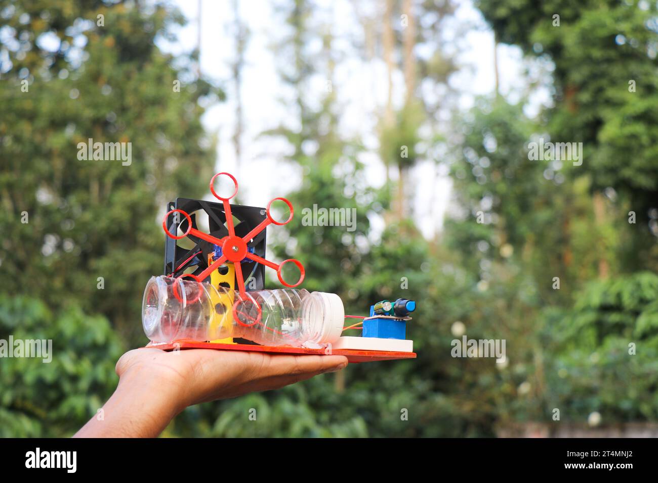 Soap bubble blowing machine built at home using some electronics held in the hand outdoors Stock Photo
