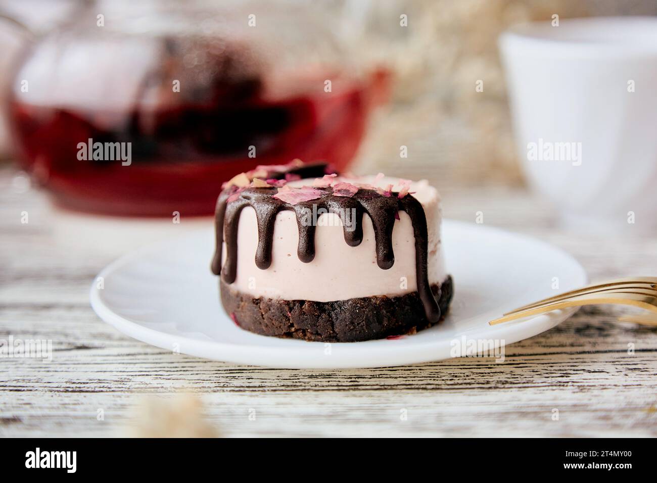 Pink vegan no baking cake with carob and berries organic tea breakfast Stock Photo