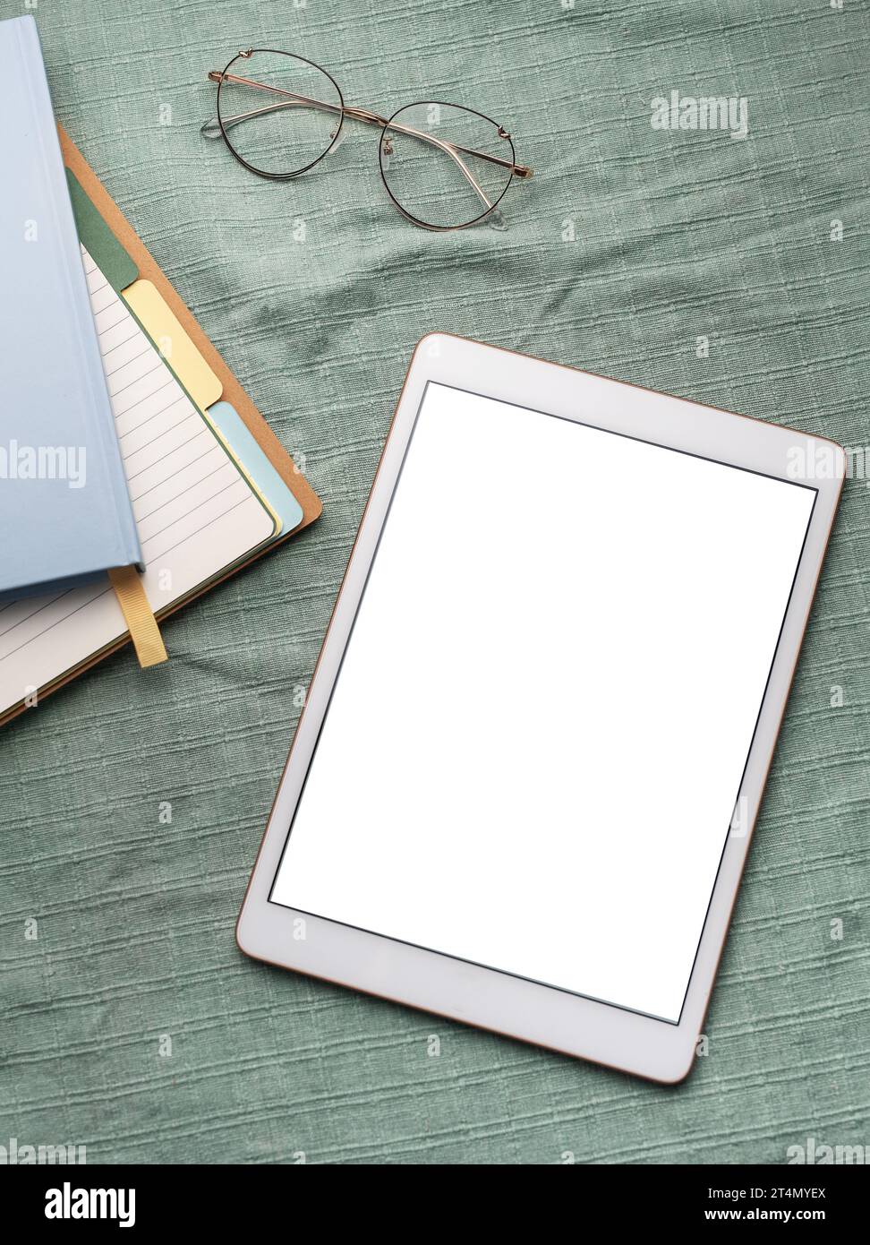 Tablet empty white screen and notebooks  on the office desk Stock Photo