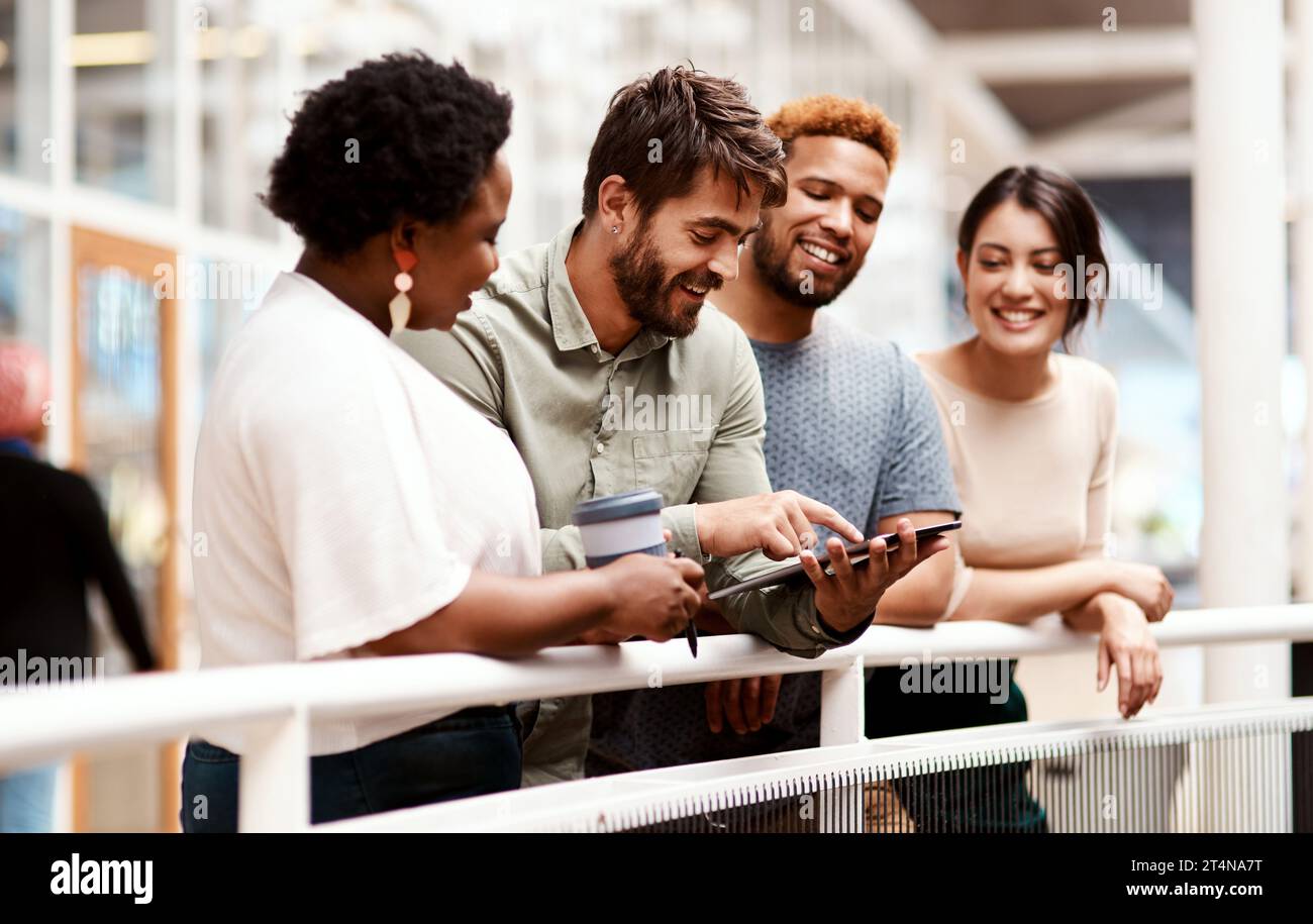 Pushing the boundaries to reach greatness together. a group of young creatives using a digital tablet together in an office. Stock Photo