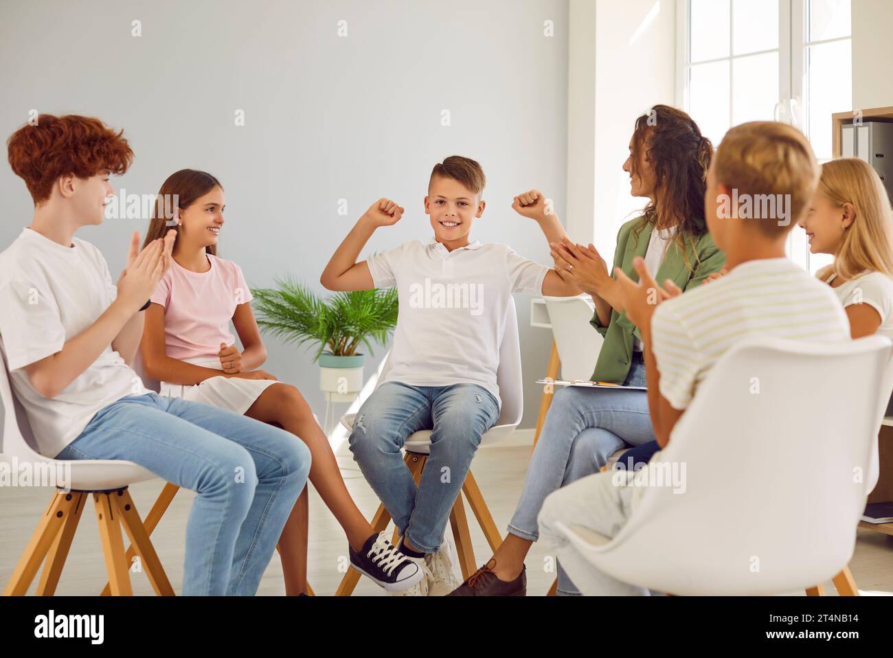 Friendly woman conducting psychological training for a group of school children. Stock Photo