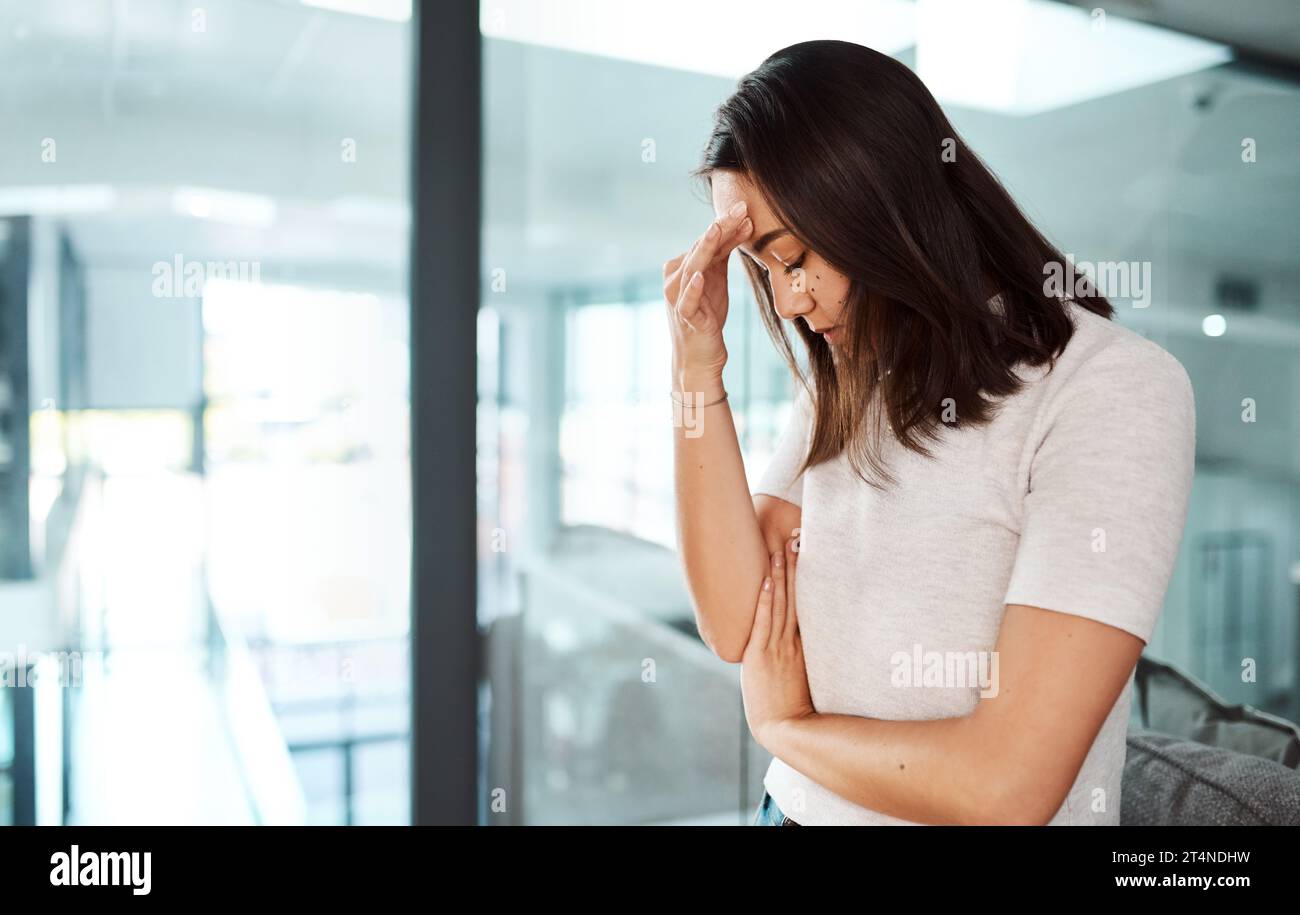 Trying to overcome the fear of losing her job. a young businesswoman looking stressed out in an office. Stock Photo