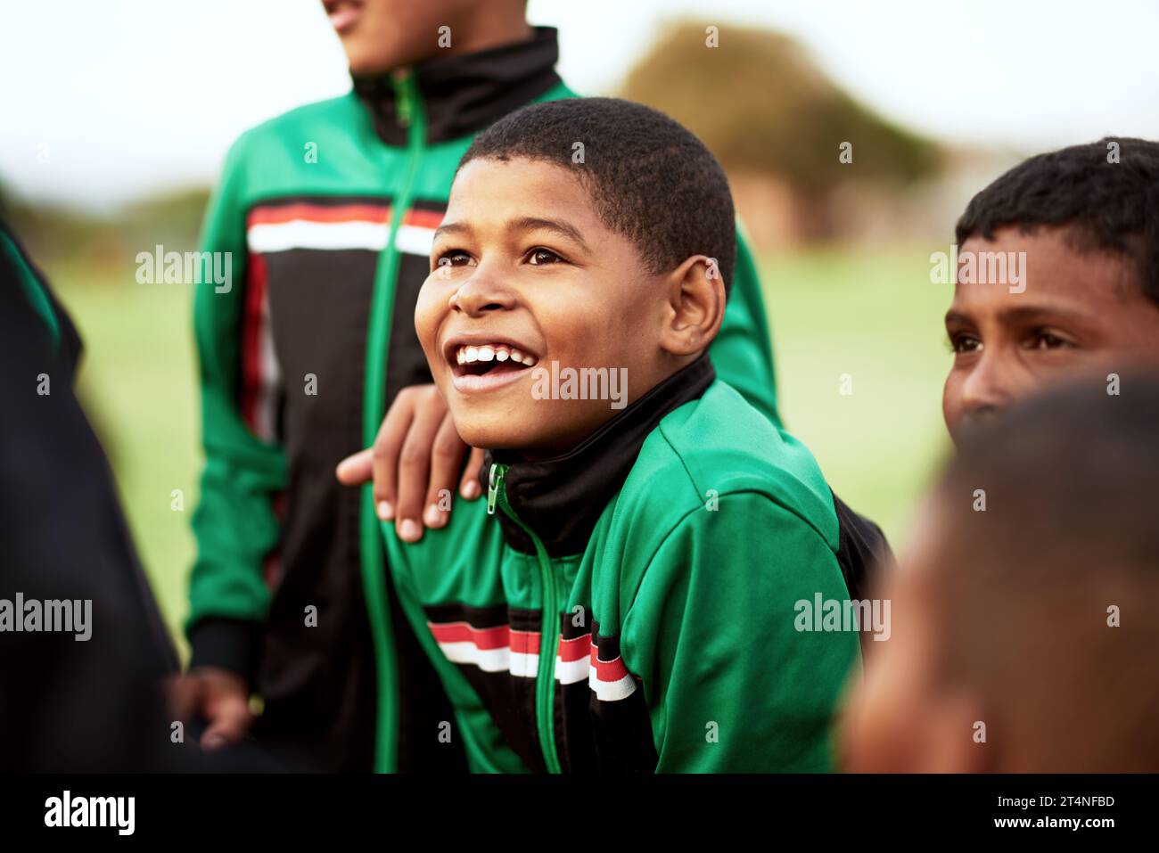 When it comes to soccer, his eyes always sparkle with excitement. a young boy standing alongside his soccer team on a sports field. Stock Photo