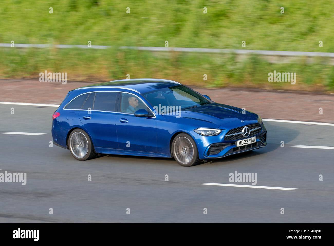 2022 Mercedes-Benz C 220 Amg Line Prem D Mhev A C220d 9G-Tronic Auto Start/Stop MHEV EQ Boost Blue Car Estate Electric Diesel 1993 cc; travelling at speed on the M6 motorway in Greater Manchester, UK Stock Photo