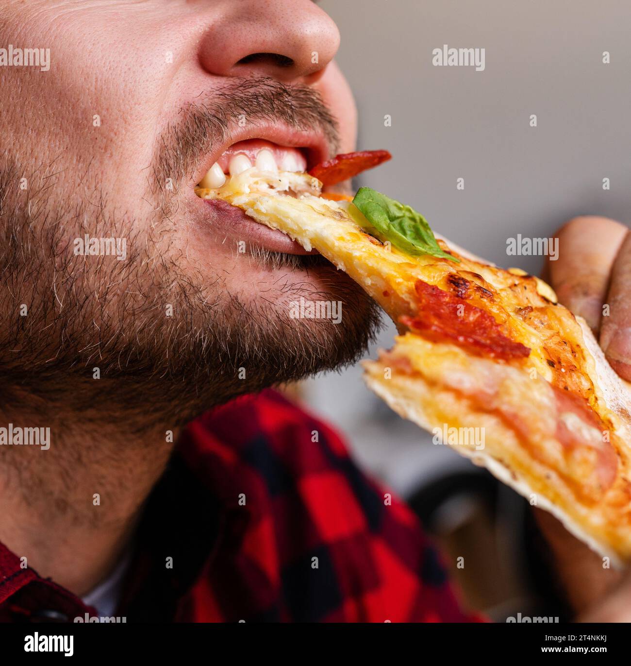 Male bearded person eating pizza close up photography. Stock Photo