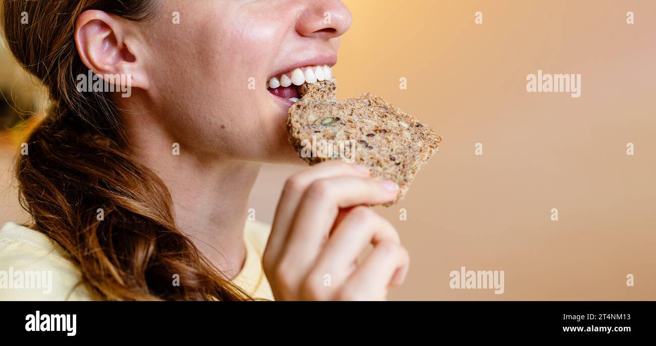 Young woman eating healthy multigrain bread close up. Stock Photo
