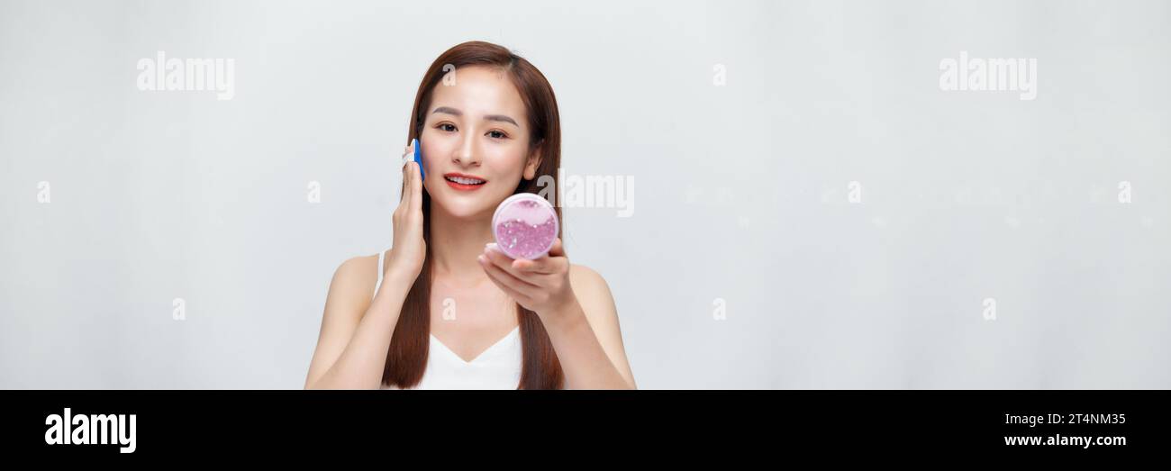 Banner of woman using powder to touch up on her face Stock Photo