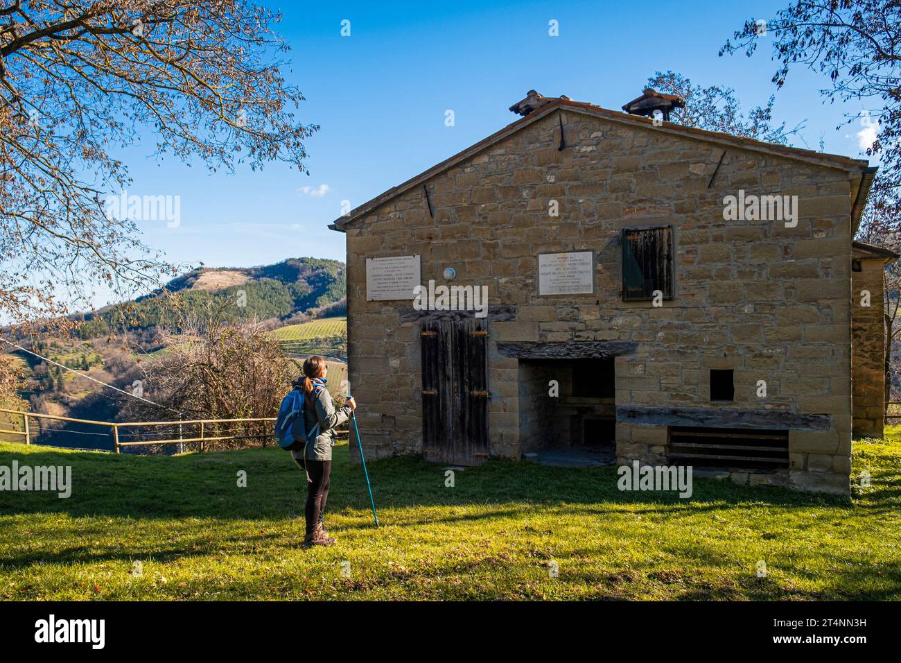 Woman with backpack admiring  the old house in the apennines. Ca Cornio, Modigliana, Forlì, Emilia Romagna, Italy, Europe. Stock Photo