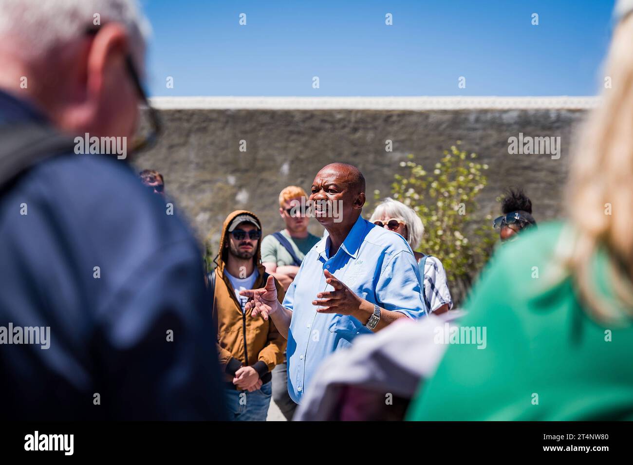 29.10.2023, xovx, Politik, Reise. Robben Island - Gefängnisinsel vor Kapstadt Führung einer Besuchergruppe durch Nelson Mandelas im Gefängnishof des Zellenblocks des Hochsicherheitstrakts auf der Gefängnisinsel Robben Island vor der Küste von Kapstadt, durch einen ehemaligen politischen Gefangenen, der der in diesem Gefängnis über viele Jahre inhaftiert wurde. In diesem Teil des Hochsicherheitstrakts verbrachte Nelson Mandela über 18 Jahre seiner Gefangenschaft in Einzelhaft. Der spätere Präsident Südafrikas Nelson Mandela verbrachte hier von 1964 bis 1982 seiner insgesamt 27-jährigen Gefangen Stock Photo