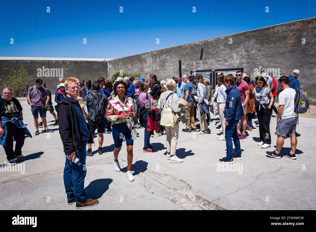 29.10.2023, xovx, Politik, Reise. Robben Island - Gefängnisinsel vor Kapstadt Besuchergruppe und Schaubild Nelson Mandelas im Gefängnishof des Zellenblocks des Hochsicherheitstrakts auf der Gefängnisinsel Robben Island vor der Küste von Kapstadt, in dem Nelson Mandela über 18 Jahre seiner Gefangenschaft in Einzelhaft inhaftiert wurde. Der spätere Präsident Südafrikas Nelson Mandela verbrachte hier von 1964 bis 1982 seiner insgesamt 27-jährigen Gefangenschaft, zumeist bei Einzelhaft und unmenschlichen Bedingungen. Robben Island ist eine Insel zwölf Kilometer vor der südafrikanischen Stadt Kapst Stock Photo