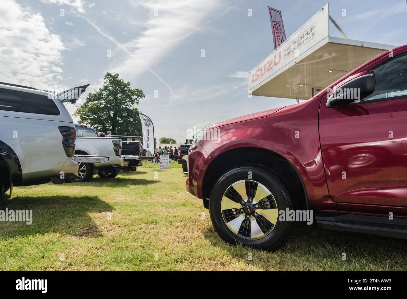 Nantwich, Cheshire, England, July 26th 2023. View of a red Isuzu D-Max alloy wheel with a trade show stand in the background. Stock Photo