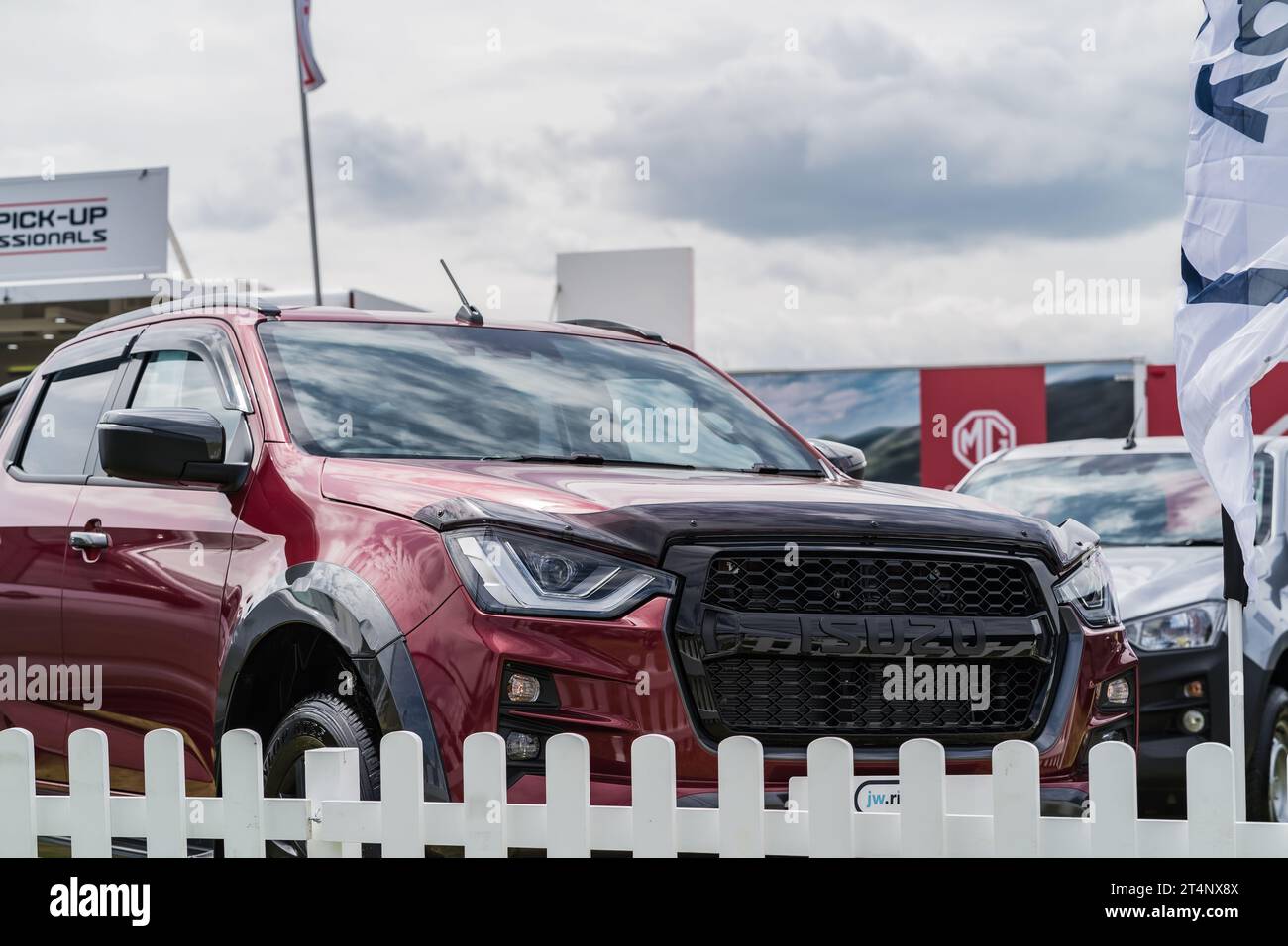 Nantwich, Cheshire, England, July 26th 2023. View of an Isuzu front grille and headlights with a white fence in the foreground. Stock Photo