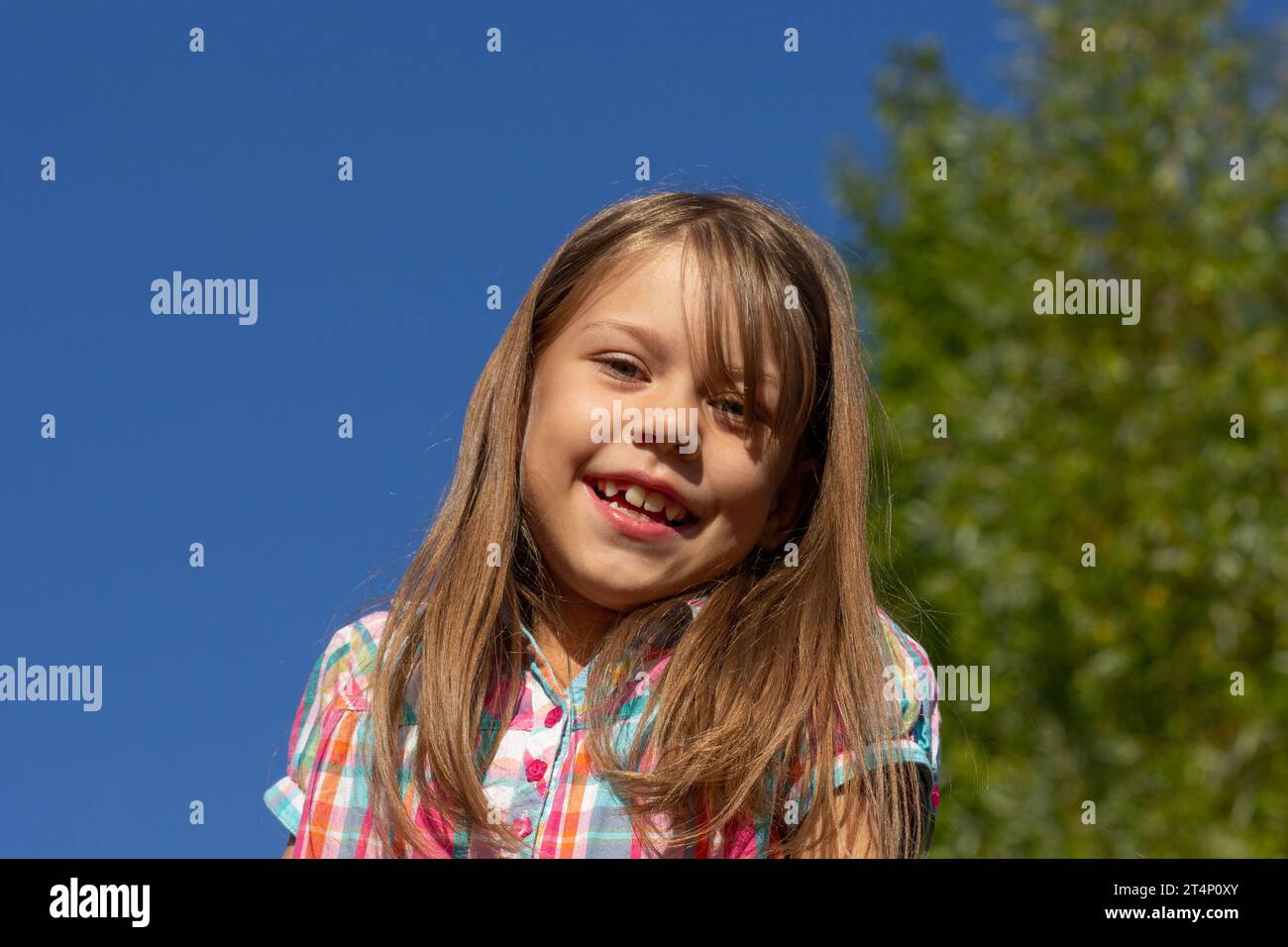 Portrait of little girl smiling and looking at camera Stock Photo - Alamy