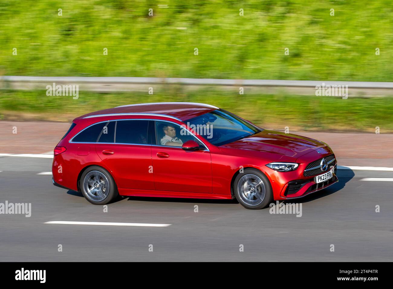 2023 Mercedes-Benz C 220 Amg Line D Mhev Auto C220d 9G-Tronic Auto Start/Stop MHEV EQ Boost Red Car Estate Electric Diesel 1993 cc; travelling at speed on the M6 motorway in Greater Manchester, UK Stock Photo