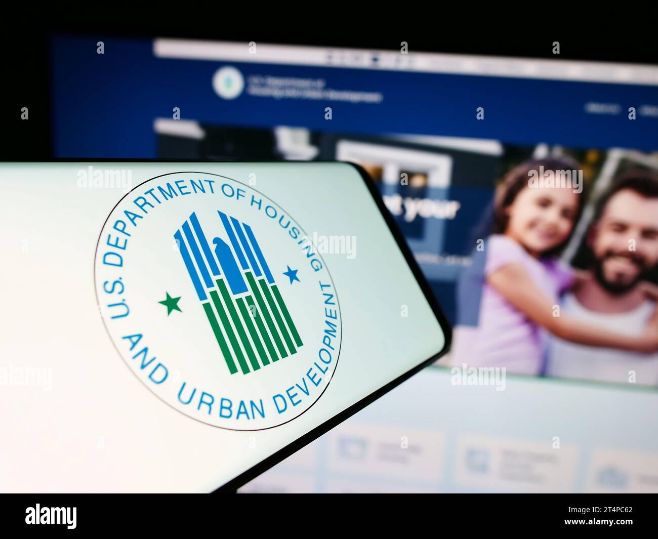 Smartphone with logo of US Department of Housing and Urban Development (HUD) in front of website. Focus on center-right of phone display. Stock Photo