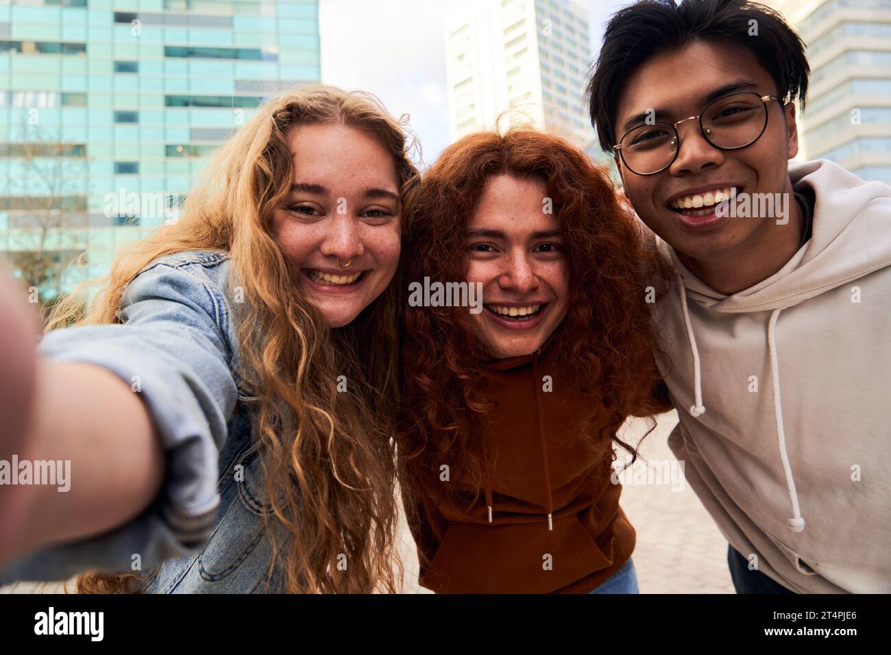 Group of student friends having fun outdoors taking a selfie looking at camera smiling. Stock Photo