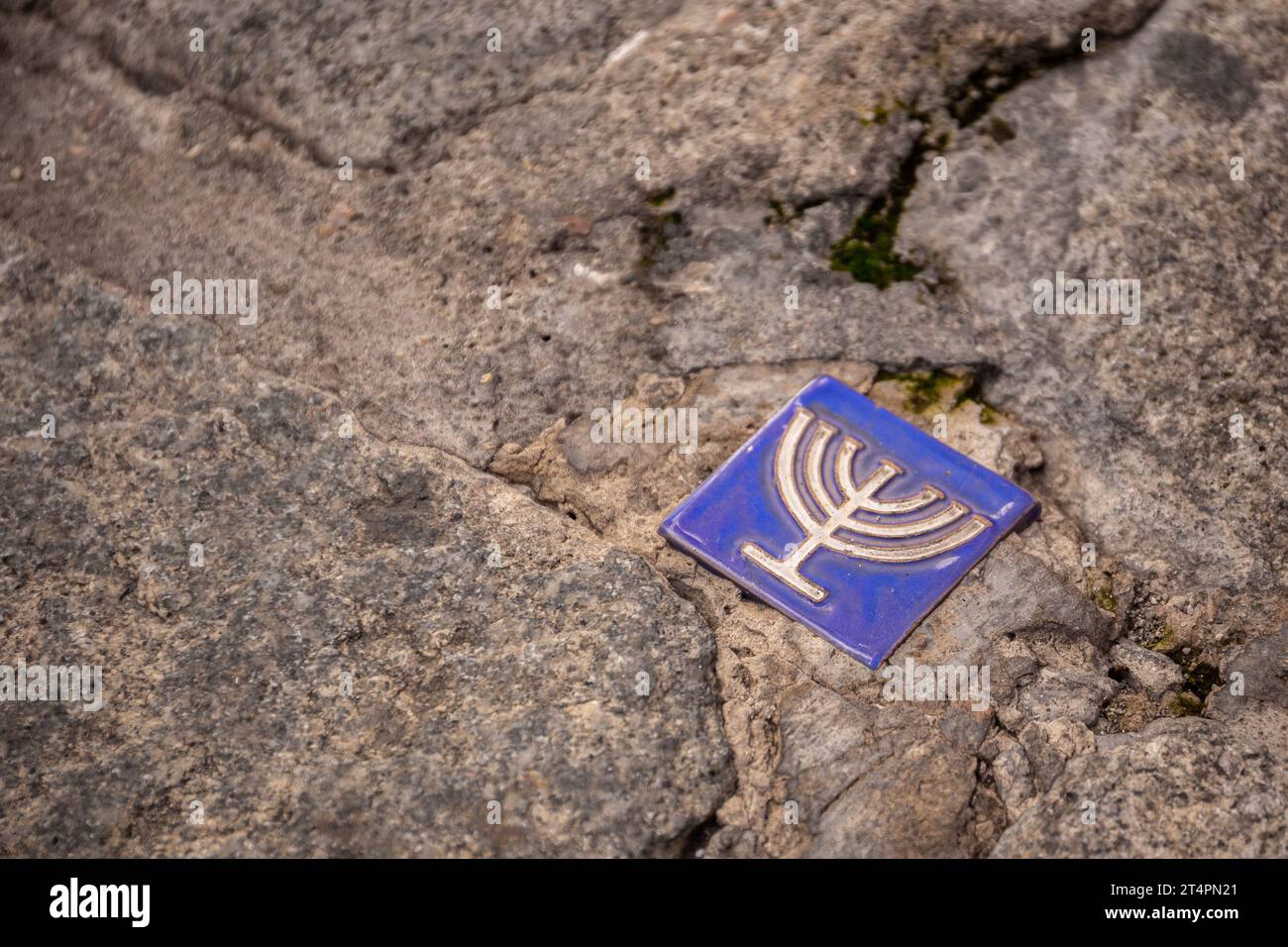 Small blue tile with menorah symbol embedded in the pavement of the former Jewish quarter, Toledo, Spain. Stock Photo
