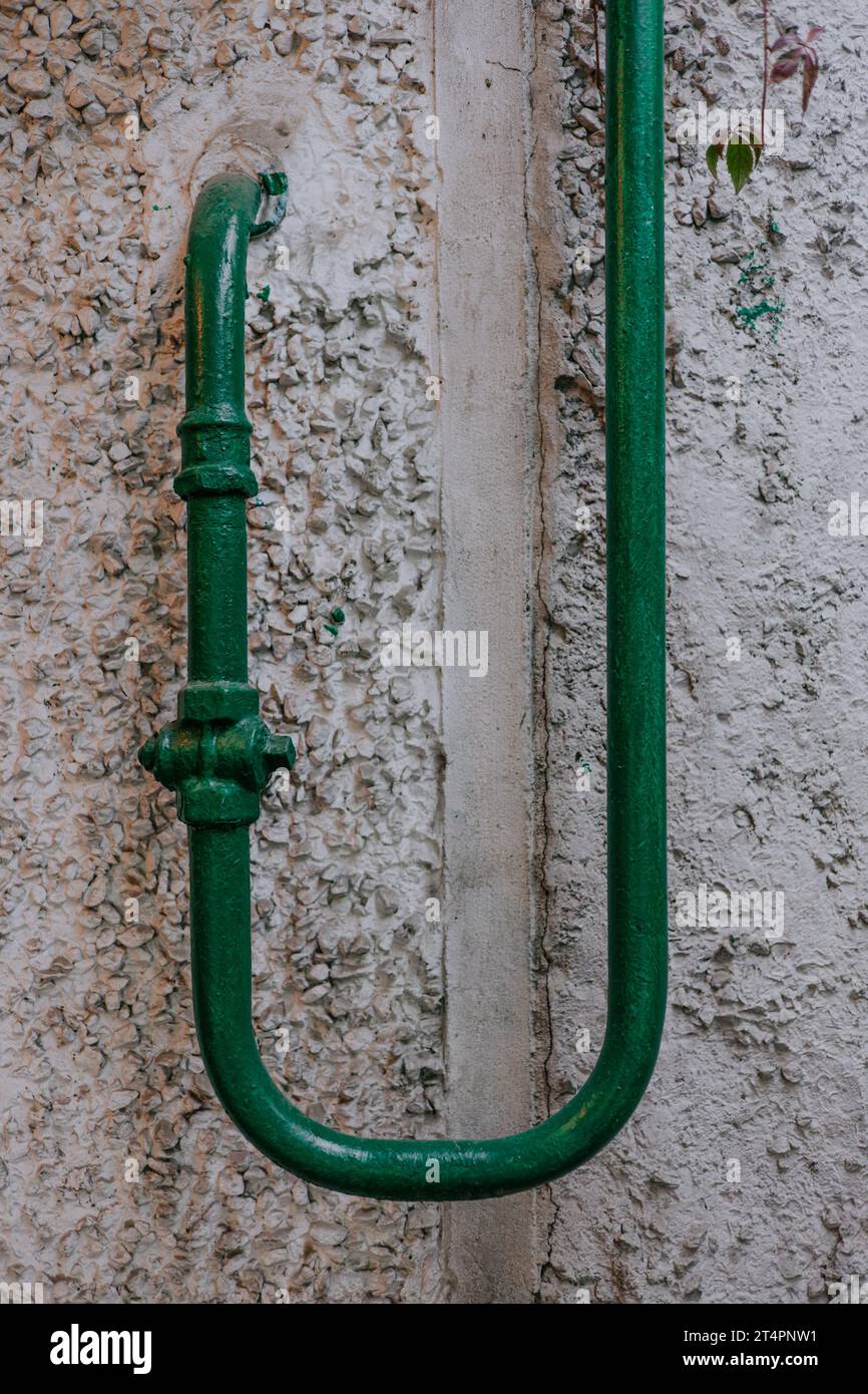 Old Curved green gas pipe enters the house close. Gasification of regions. Stock Photo