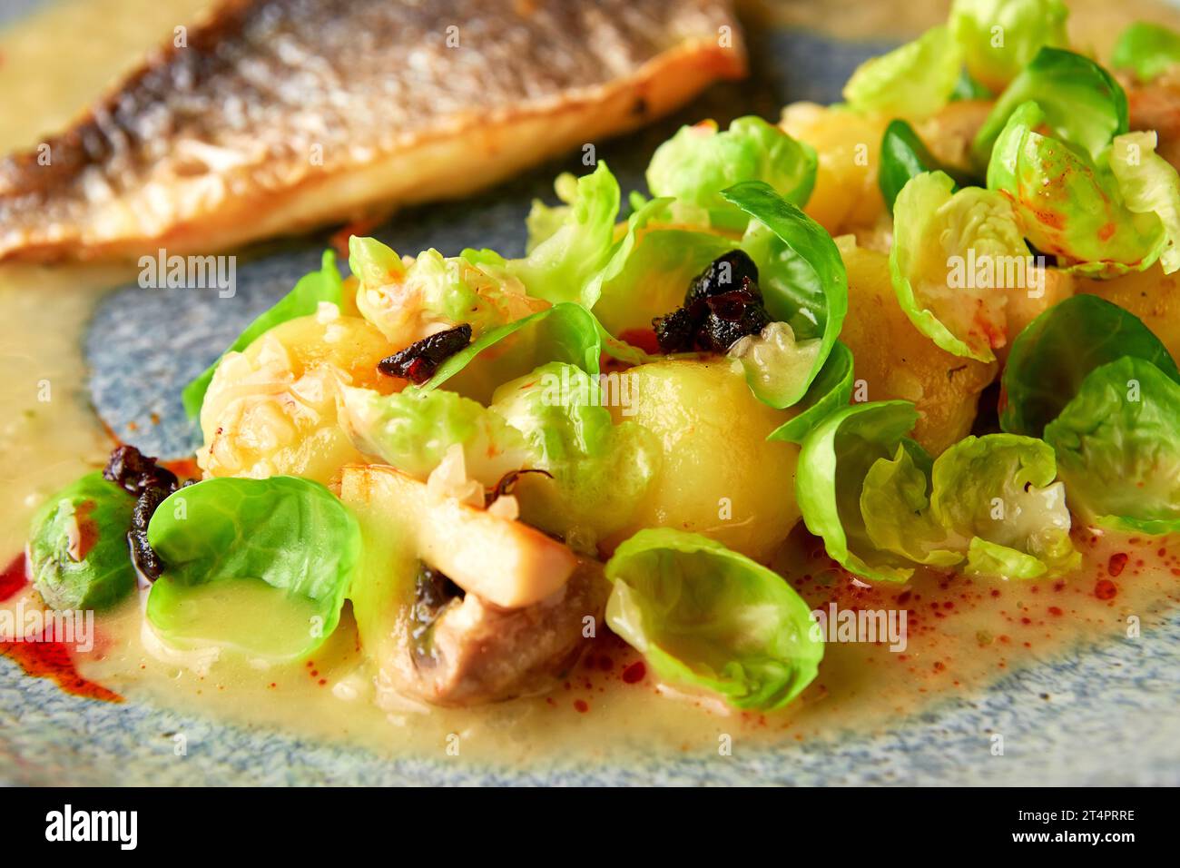 Grilled sea bass fillet served with steamed brussel sprouts, roasted